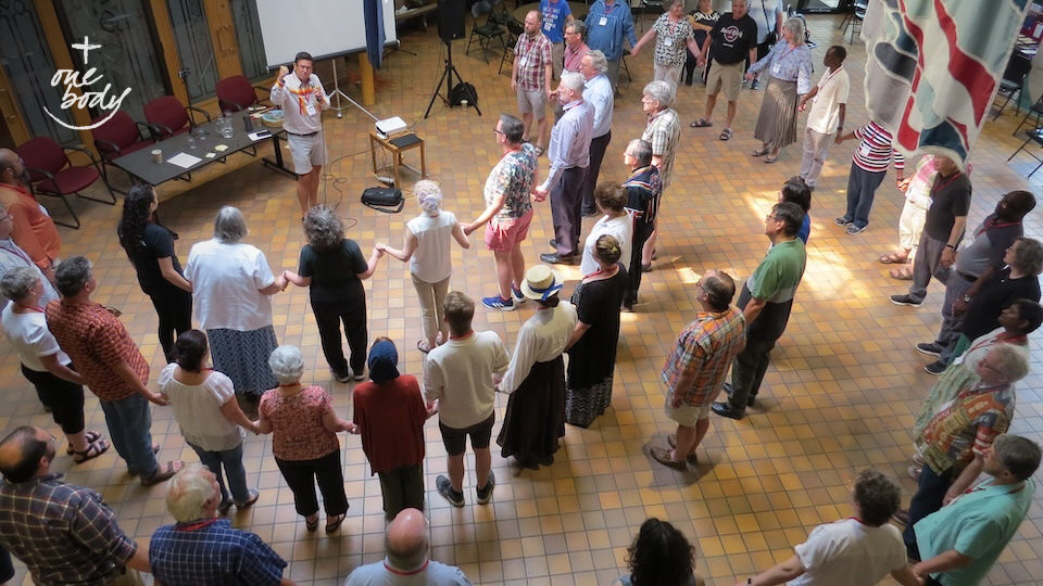 Archdeacon Travis Enright, Lodge Elder of the Standing Stones Sacred Lodge in the Anglican Diocese of Edmonton, leads a Round Dance at the conclusion of the Pêhonân gathering in June, 2023. Photo courtesy of the Canadian Council of Churches