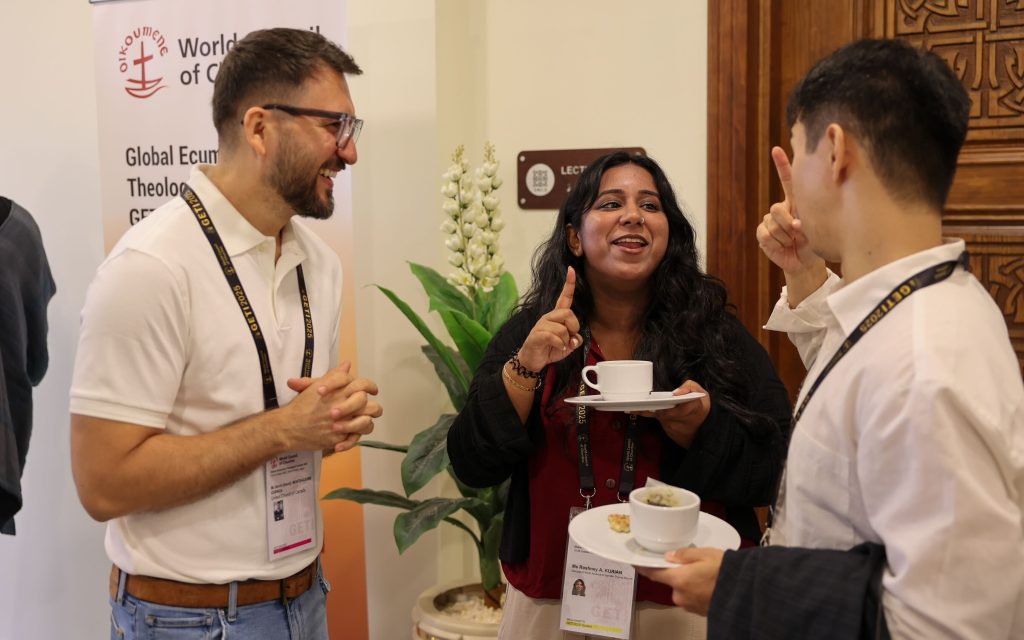 Three people speaking to each other at a conference.